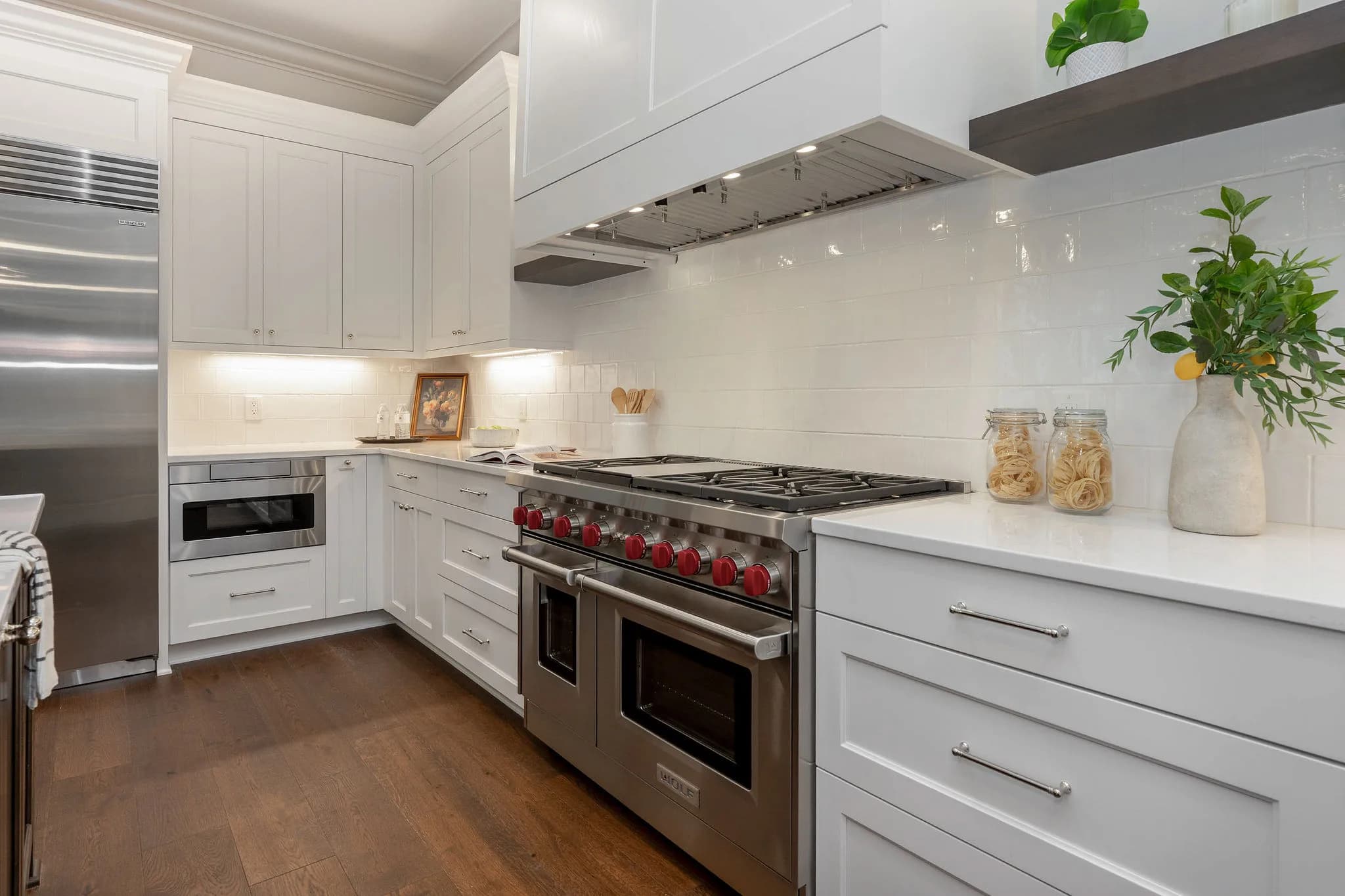 Wolf range and custom hood against a marble backsplash